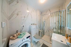 a bathroom with a washer and a toilet and a shower at Flex SelfCheckIns 191 - Zagreb - 2 Bedrooms - Parking - Loggia in Zagreb