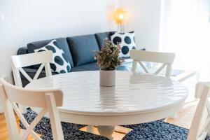 a white table and chairs in a living room with a couch at Flex SelfCheckIns 191 - Zagreb - 2 Bedrooms - Parking - Loggia in Zagreb