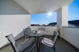 a balcony with a table and chairs and a window at Flex SelfCheckIns 191 - Zagreb - 2 Bedrooms - Parking - Loggia in Zagreb