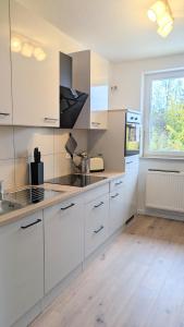a kitchen with white cabinets and a window at HYGGE HOMES - Apartment 'Stilla' in Celle