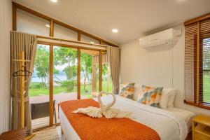 a bedroom with a bed and a large window at The Hilltop Erawan in Si Sawat