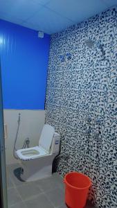 a bathroom with a toilet and a blue light at Kaafirana Adventure Camps and Cottages in Shivpuri