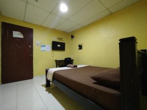 莎阿南KristaI Inn Hotel Shah Alam的卧室配有一张黄色墙壁上的床