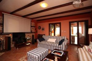 ein Wohnzimmer mit zwei Sofas und einem Flachbildfernseher in der Unterkunft Villa Artemis in Vathírrevma