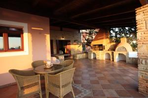eine Außenterrasse mit einem Tisch und Stühlen in der Unterkunft Villa Artemis in Vathírrevma