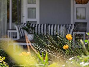 een bankje voor een huis met bloemen bij La Dolce Vita Gordon’s Bay in Gordonsbaai