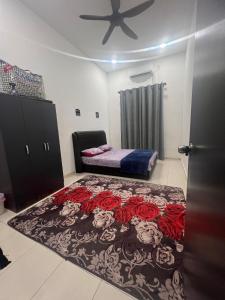 a bedroom with a bed with red roses on it at Hasya Guesthouse in Seri Iskandar
