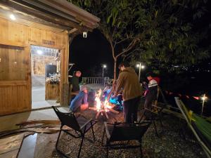 a group of people standing around a fire at night at The Zen House Sapa in Sa Pa