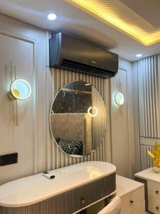 una habitación con un espejo redondo y una mesa en Osma Living Apartment Lahore, en Lahore