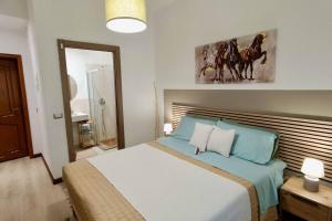 a bedroom with a large bed with blue sheets at Arcu de chelu - guest house in Modolo