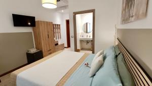 a bedroom with a bed with a sink and a mirror at ARCU DE CHELU - GUEST HOUSE in Modolo