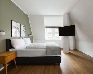 een slaapkamer met een bed en een flatscreen-tv bij Limehome Ravensburg Marienplatz in Ravensburg
