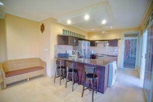 cocina con encimera y barra con taburetes en Maria Secret Villa, en Lovina