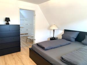 ein Schlafzimmer mit einem Bett, einer Kommode und einem Spiegel in der Unterkunft Modernes & zentral gelegenes Ferienhaus mit Garten und Parkplatz in Memmingen