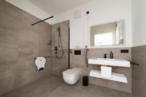 een badkamer met toilet, wastafel en douche bij Limehome Ravensburg Marienplatz in Ravensburg +33 foto's