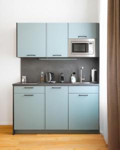 een keuken met witte kasten en een magnetron bij Limehome Ravensburg Marienplatz in Ravensburg