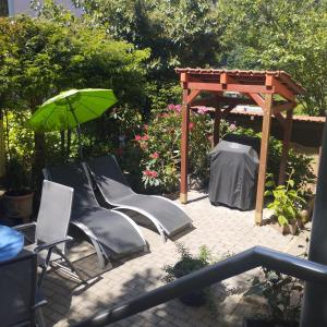 a group of chairs and an umbrella on a patio at Nichtraucherferienwohnung-Neckarblick ZE-2022-74-WZ-118A in Heidelberg