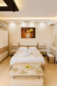 a bedroom with two beds and a painting on the wall at Jacuzzi Escape in Tirana