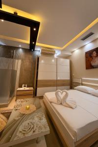 two beds in a room with two white towels at Jacuzzi Escape in Tirana