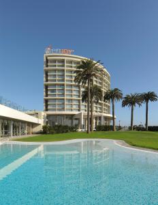 um hotel com piscina em frente a um edifício em Enjoy Coquimbo em Coquimbo