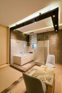 a bathroom with a tub and a table and a chair at Jacuzzi Escape in Tirana