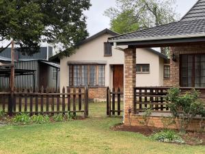 a wooden fence in front of a house at Pavlovna Cozy 2 Cottage in Himeville