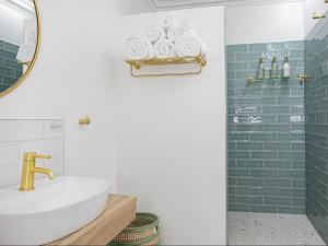 een badkamer met een wastafel en een spiegel bij La Dolce Vita Gordon’s Bay in Gordonsbaai +21 foto's