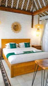 a bedroom with a large bed with green pillows at Sampai Villa Nayan in Yogyakarta