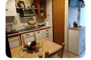 a kitchen with a table with a bowl of fruit on it at Lo Chalet di Loredana in Pisa