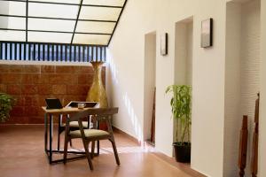 a room with a table and a chair with a laptop at Nila by Raho - Secluded Villa with Estate View in Siddapur