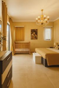 un dormitorio con una cama y una cuna en Spacious Modern 3BR Oasis Villa with Private Pool, en Nadur