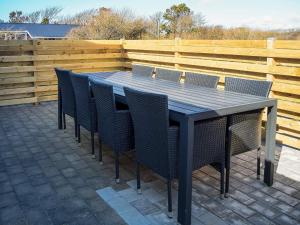 Una mesa negra con sillas y una valla de madera. en 12 person holiday home in Vestervig-By Traum, en Vestervig