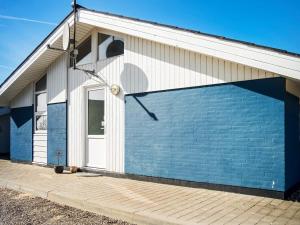 un edificio azul y blanco con un gran garaje en 12 person holiday home in Vestervig-By Traum, en Vestervig