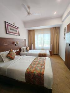 Una habitación de hotel con dos camas y una ventana. en Amritara Ramila Kutir, en Ayodhya