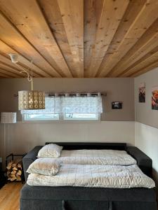 a bed in a bedroom with a wooden ceiling at Camp Caroli Olala in Jukkasjärvi
