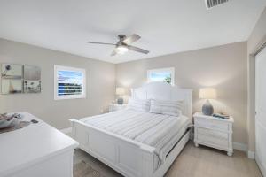 a white bedroom with a bed and a ceiling fan at Seashells #42 in Ybel