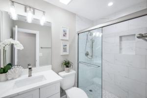 a white bathroom with a shower and a toilet at Seashells #42 in Ybel