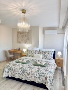 a bedroom with a large bed and a chandelier at HelloWine Apartman in Eger