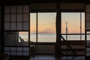 a room with a window with a view of the ocean at 砂浜まで10秒 海と桟橋を一望できるHaraoka House in Minamiboso