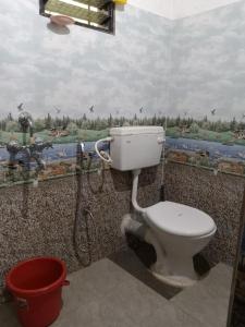 SawantwadiNeha Guest House的浴室内的卫生间,墙上有绘画作品