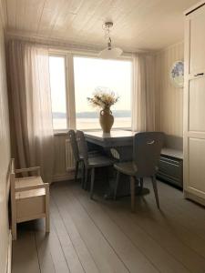 a dining room with a table and chairs and a window at Romantic Summer House On Orust in Stillingsön +32 photos