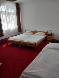 a bedroom with two beds and a window at Menta Rooms & Bar in Kapuvár