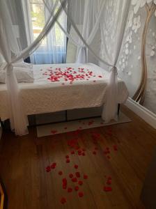 a bedroom with a bed with red roses on the floor at Glamour Jacuzzi Privé Chambéry in Chambéry