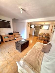 a living room with a bed and a flat screen tv at Casa medieval Cal Moliner in Omells de Nagaya