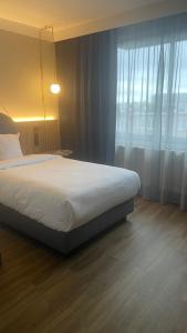a bedroom with a bed and a large window at Gresham Belson Hotel Brussels in Brussels