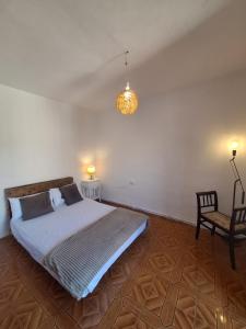 a bedroom with a bed and a chair and a lamp at Casa medieval Cal Moliner in Omells de Nagaya +30 photos
