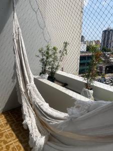 a hammock in a room with a window at Apartamento aconchegante in Belém