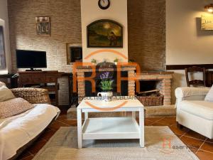 a living room with a table and a fireplace at 15A08 El Rosal By R2R in Buelna