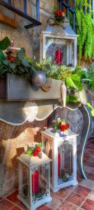 zwei weiße Tische mit Blumen und Pflanzen an einer Wand in der Unterkunft La Ermita de los Llanos in Arenas de San Pedro