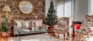 ein Wohnzimmer mit einem Weihnachtsbaum in der Ecke in der Unterkunft La Ermita de los Llanos in Arenas de San Pedro